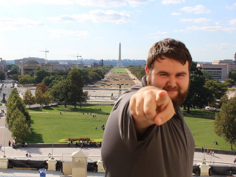 Student pointing with Washington Monument in the background
